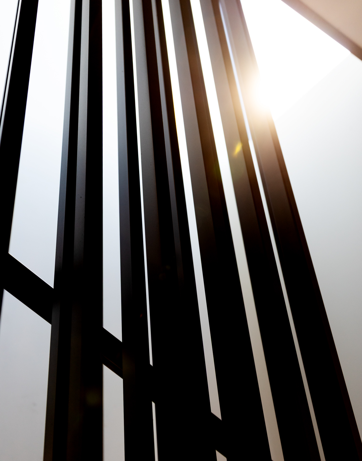 Angled shot of iron stair railing showing clean lines, depth, and precision craftsmanship.